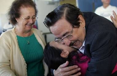 grandparents embrace granddaughter 