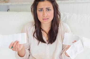 Young woman getting stressed over bills