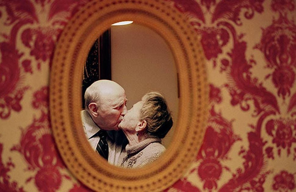 An elderly couple kissing