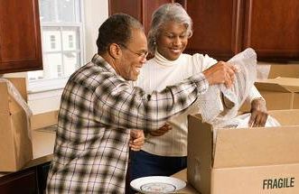 an african american couple packing boxes in a kitchen