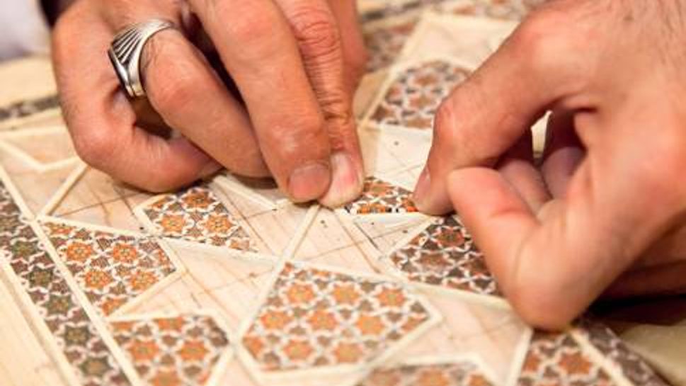 Person creating a mosaic tile design