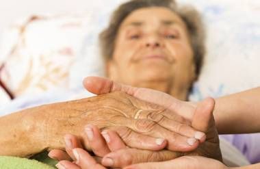 Caring Nurse Holding Patients Hands