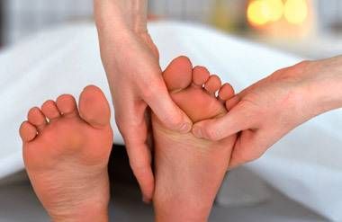 Person receiving reflexology foot massage
