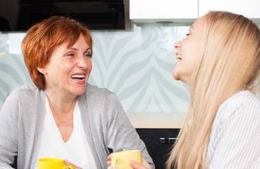 Two women laughing over coffee