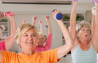 Older women exercising with dumbbells in a health club