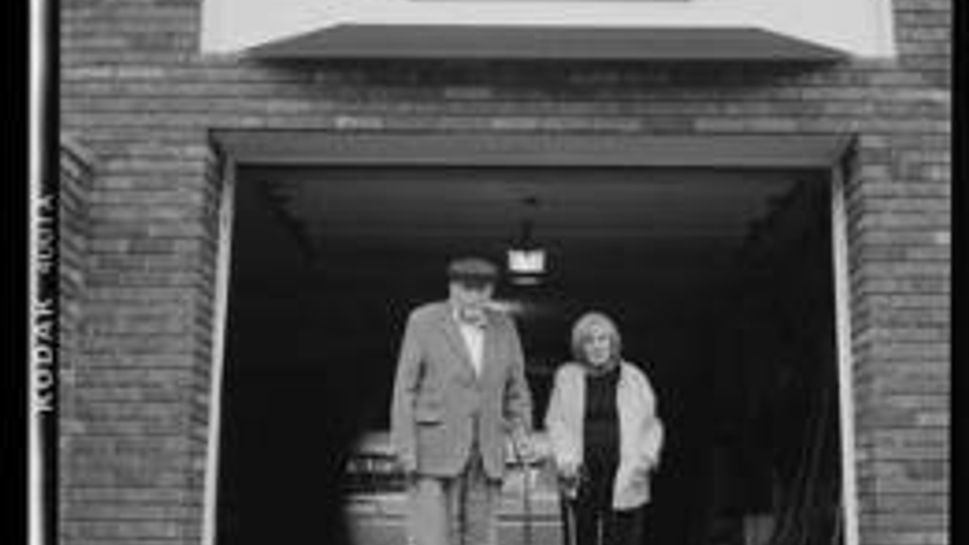 joe and mary white standing in front of a garage