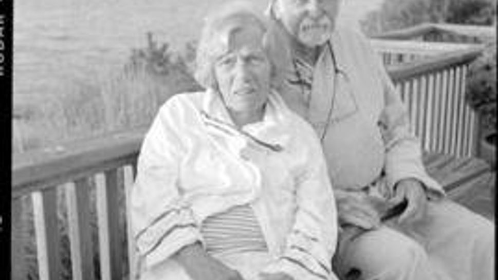 mary and joe white sitting on a bench in front of a body of water
