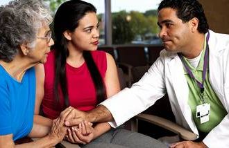 latino senior woman with daughter and healthcare counselor