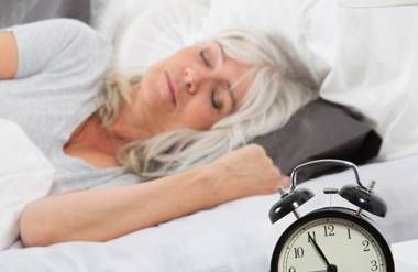 Woman sleeping with alarm clock