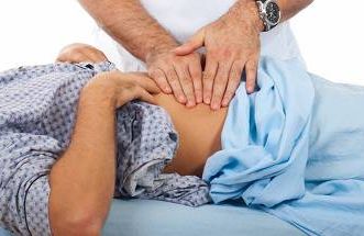 a doctor pressing on a patient's abdomen