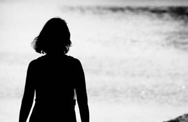 Woman walking alone along lake