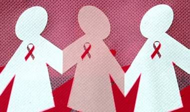 paper cutouts of women holding hands and wearing breast cancer symbols