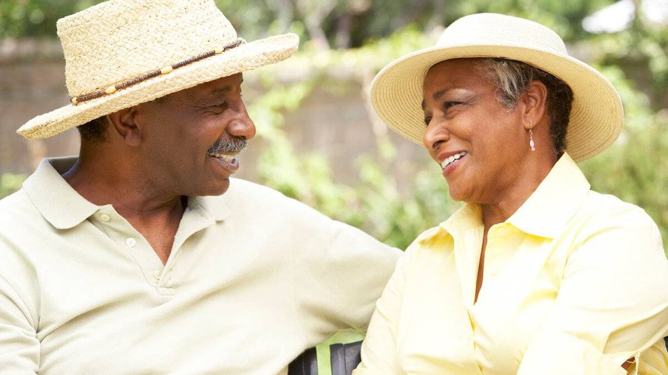 Senior Couple Relaxing In Garden Together