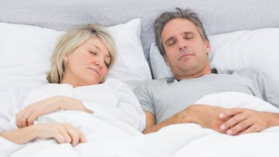 Couple sleeping peacefully in their bed