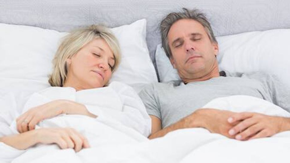 Couple sleeping peacefully in their bed