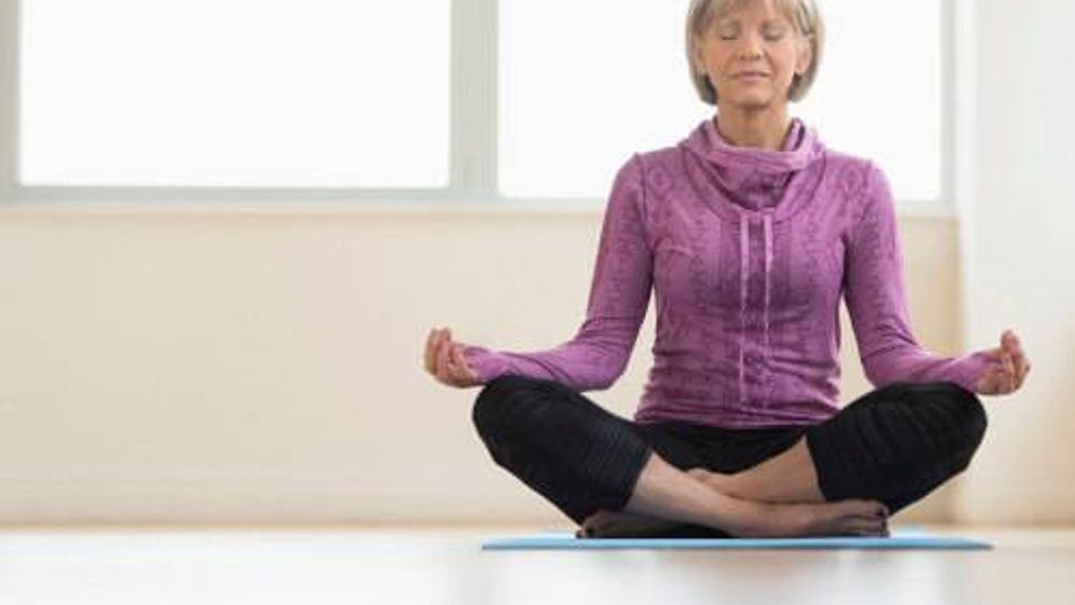 Mature Woman With Eyes Closed Sitting In Lotus Position