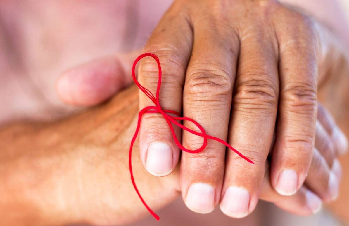 Woman with red string tied around her finger