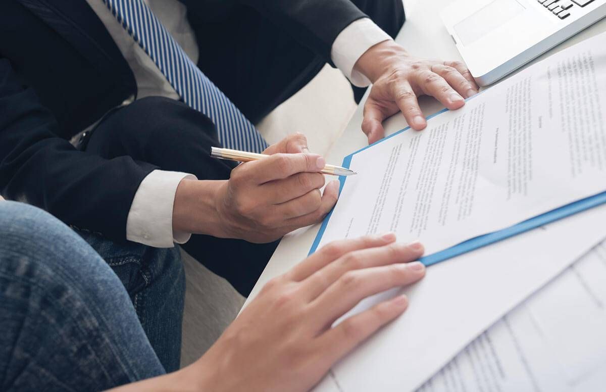 Two people reviewing and signing paperwork