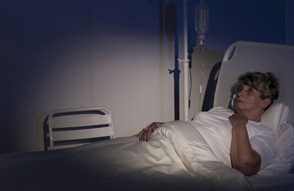 Woman trying to sleep in hospital bed