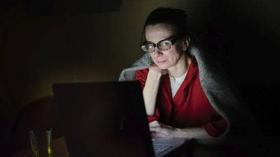 Woman on computer in dark
