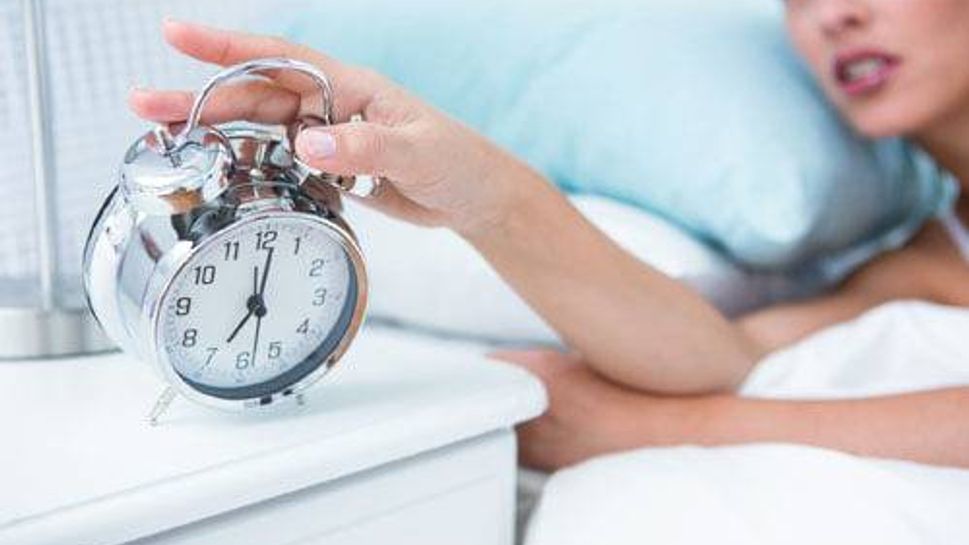 Woman pushing alarm clock