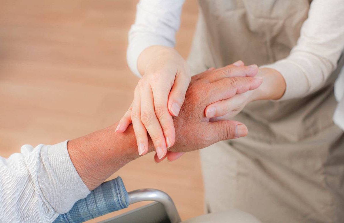 Caregiver holding patient hand