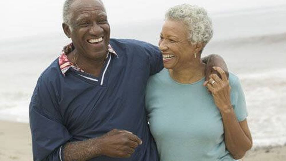 Mature man and woman walking along the beach