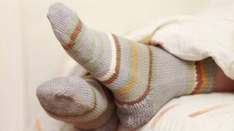 A person wearing socks in bed