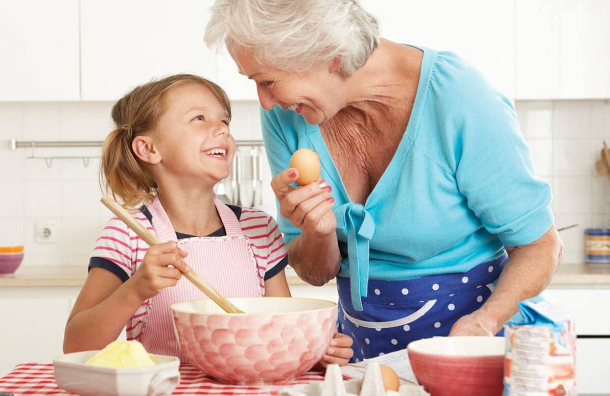 Grandmother cooking with her granddaughter