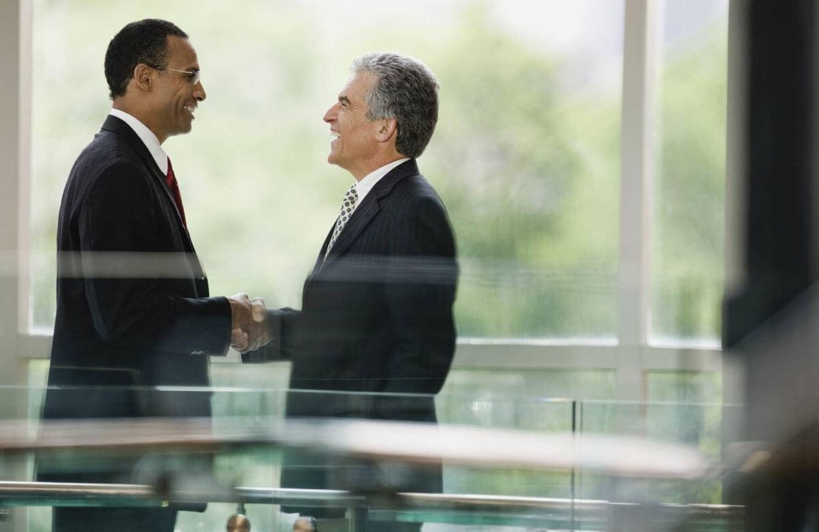 Two smiling businessmen shaking hands