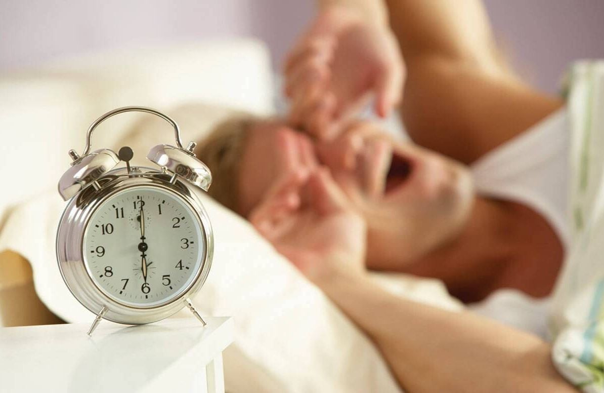 Person waking up to an alarm clock