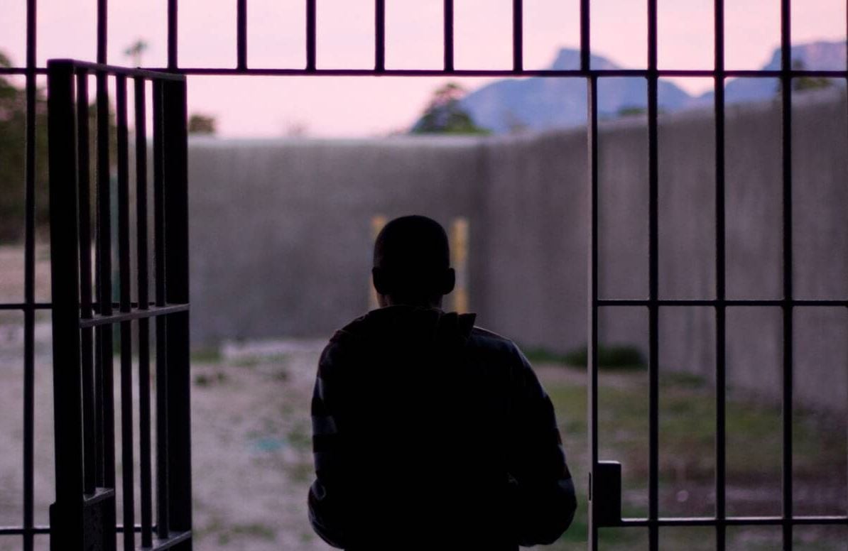 man standing outside of jail cell