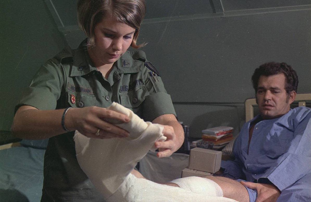 Vietnam 1st Lt. Elaine H. Niggemann changes a surgical dressing for Mr. James J. Torgelson at the 24th Evacuation Hospital.