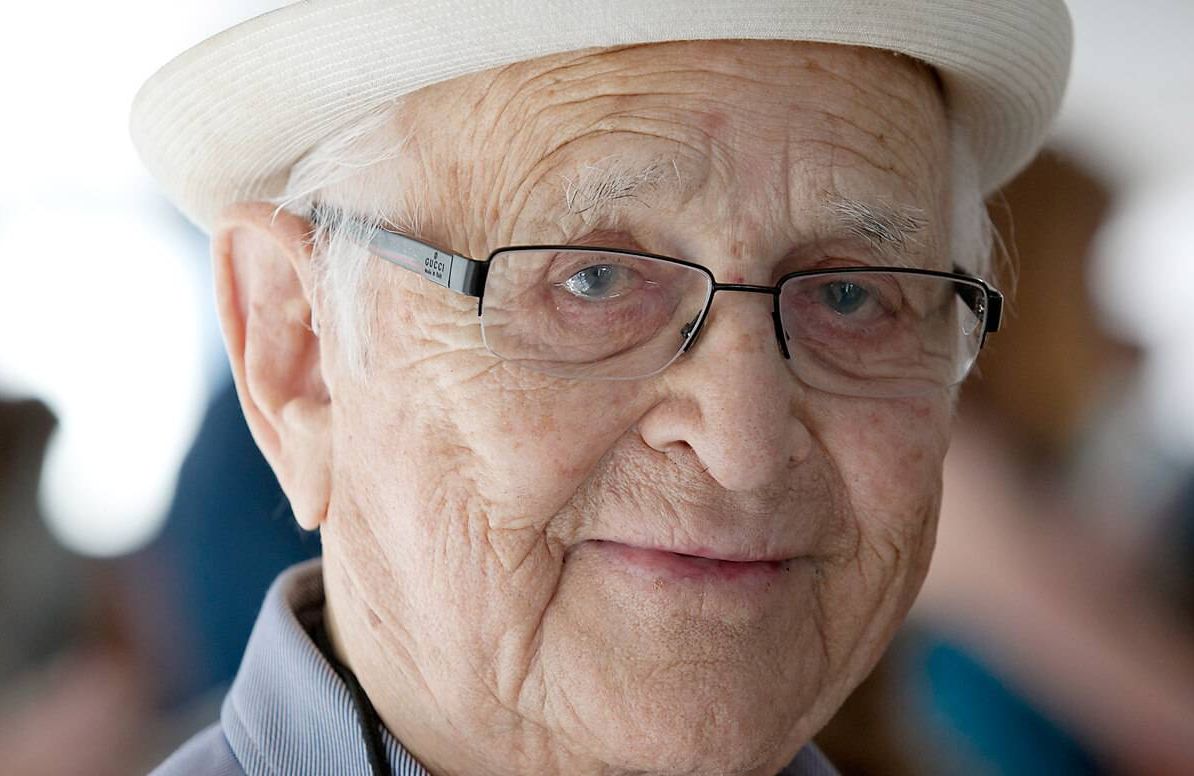 gentleman with glasses and a white hat looking at the camera