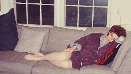 Melissa sleeping on the couch in her childhood home.