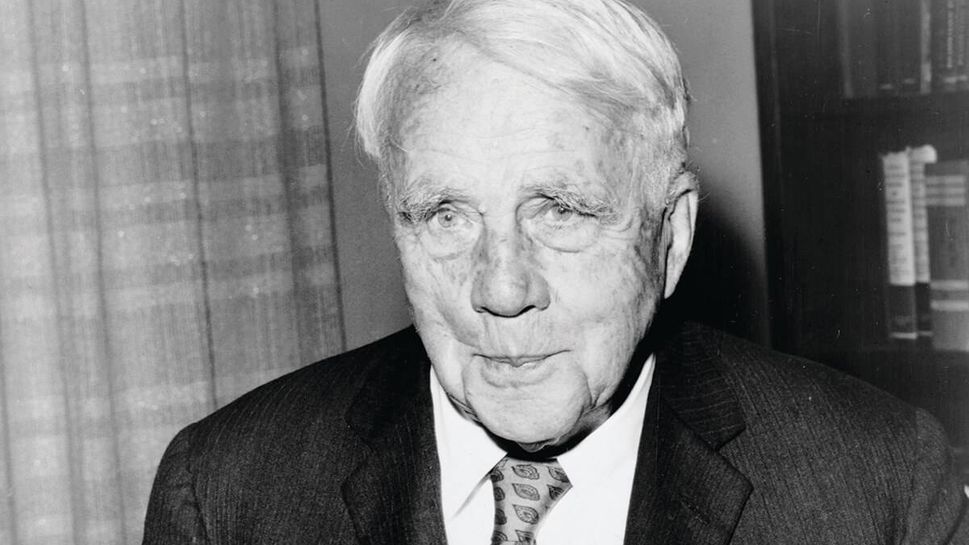 Robert_Frost, 1959, poses with his birthday cake on his 85th birthday at the Waldorf-Astoria hotel in New York City.