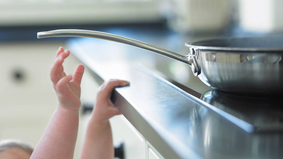 Baby reaching for skillet on stove