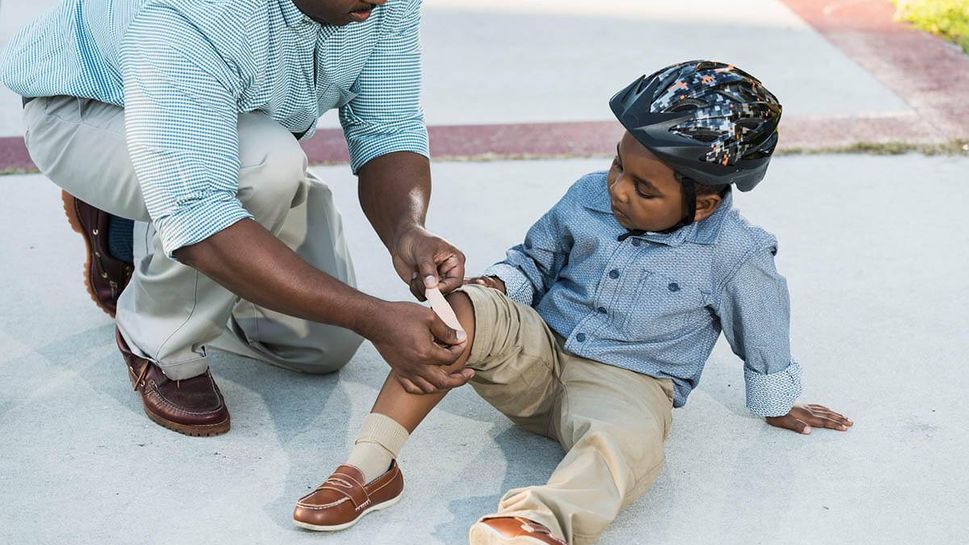 Boy getting bandage after bicycle injury