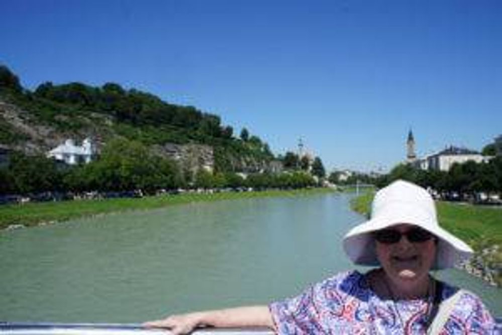 Patricia hanging on to a bridge halfway through a 90-minute walking tour in Salzburg, Austria, on a very hot day.