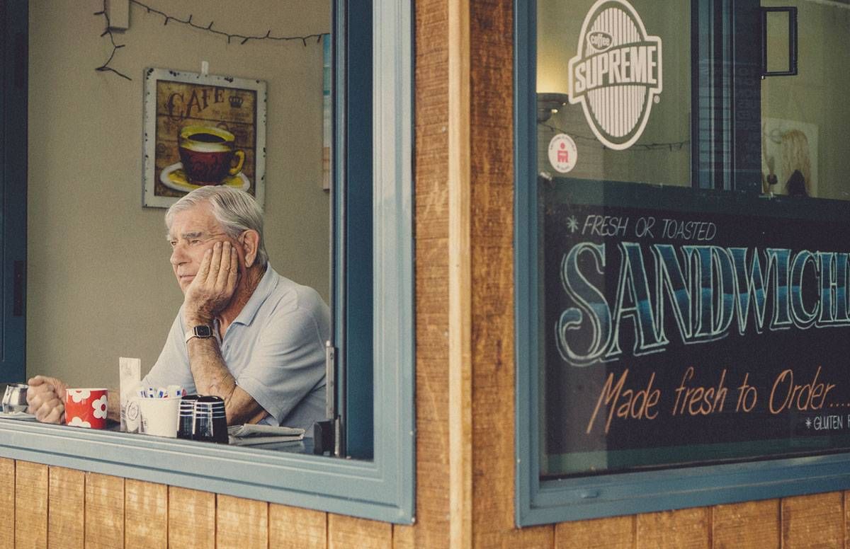 older man sitting alone in a cafe