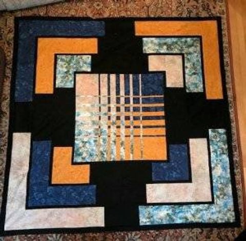 Quilt with blue, tan and black design.