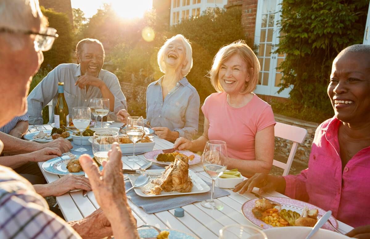 Group Of Senior Friends Enjoying Outdoor Dinner Party At Home