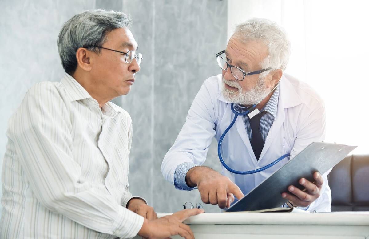 Senior male Doctor is discussing with male patient.
