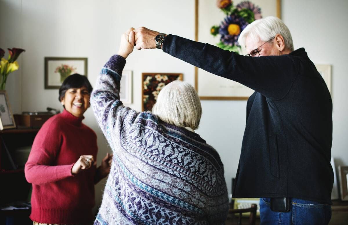 Senior friends dancing together at home