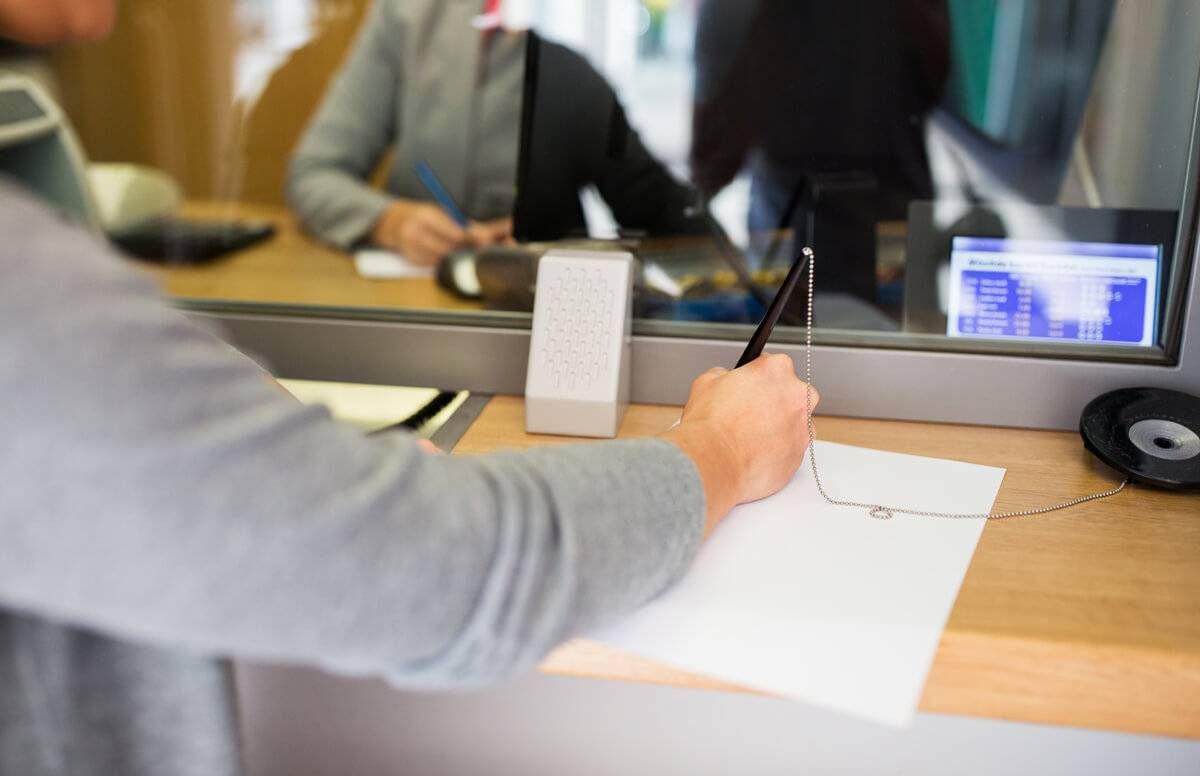 customer writing application at bank office