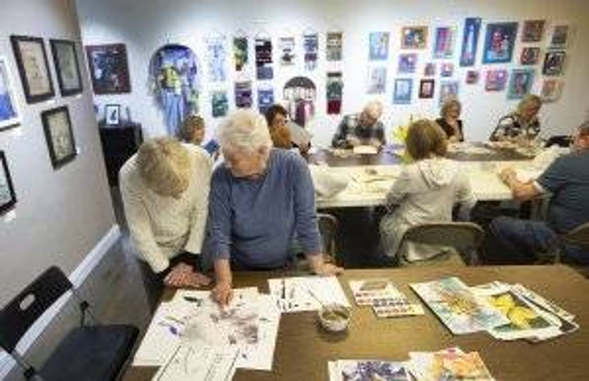 Marilynne Bradley takes time to show Mary Phelan how to do Sumie, the art of Japanese calligraphy, during class Wednesday night at the Geen Door Gallery.