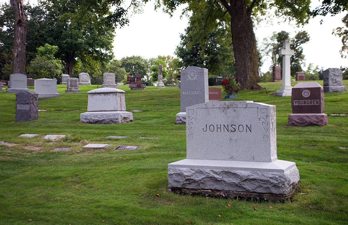 gravestones in a cemetery with one reading "Johnson" in the foreground
