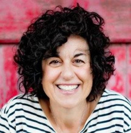 headshot of woman smiling with short curly black hair