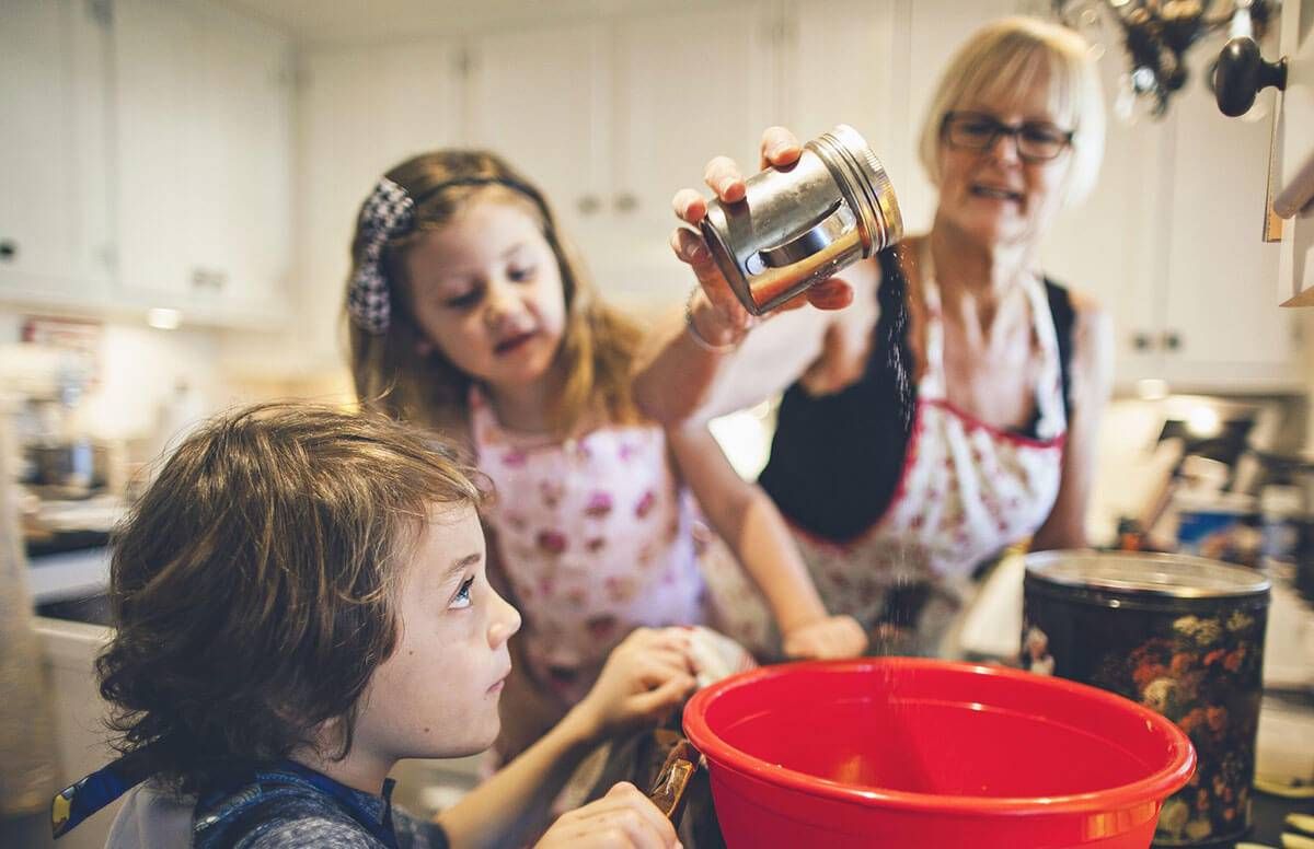 Grandmother baking with two small grandchildren