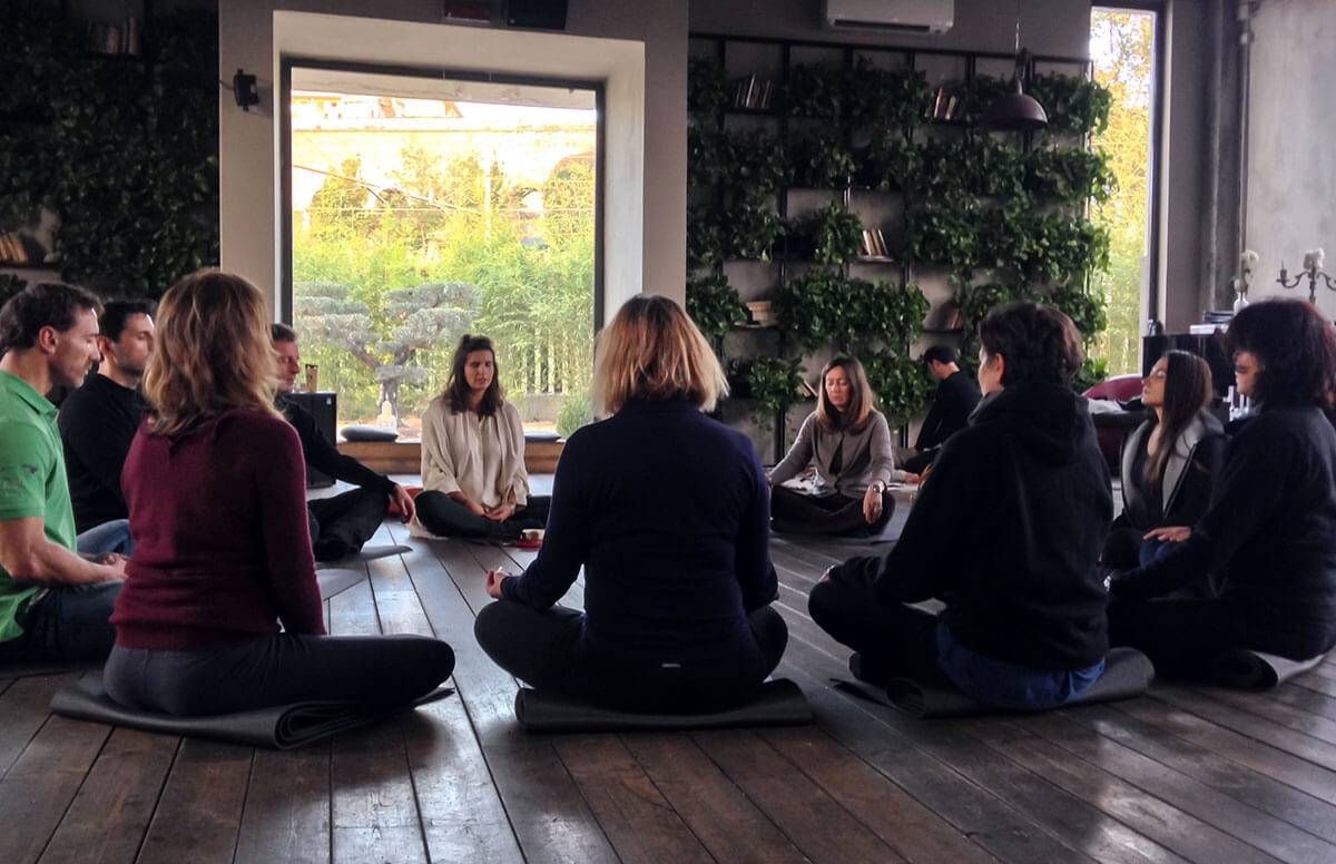 A group of adults sitting in a circle, meditating